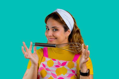 Renata Mendes em pose dinâmica com utensílio de cozinha, ideal para branding no LinkedIn e WhatsApp Business. Autoria: Bruno Arita.'