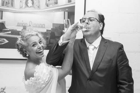 Foto de brinde dos noivos Danilo e Tabatha em momento leve, divertido e espontâneo. Registro PB por Bruno Arita.'