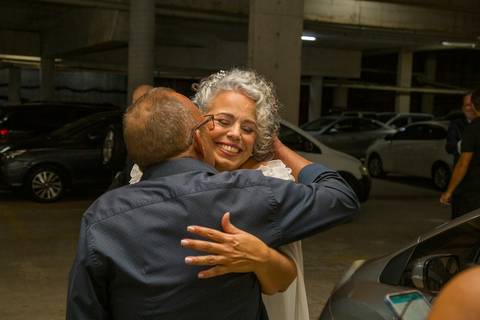 Noiva Tabatha abraçando convidado com sorriso leve e espontâneo antes da cerimônia no Morumbi. Foto por Bruno Arita.'