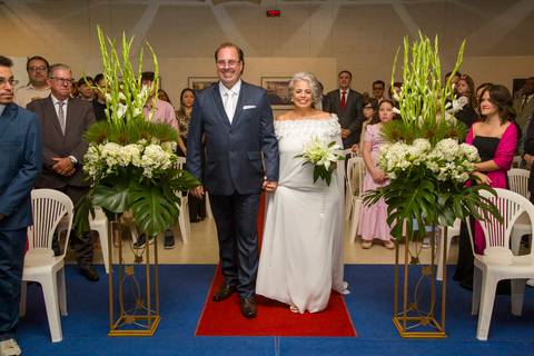 Noivo Danilo e noiva Tabatha entrando na Paróquia Santa Suzana sob os olhares do público e cercados por flores. Foto por Bruno Arita.'