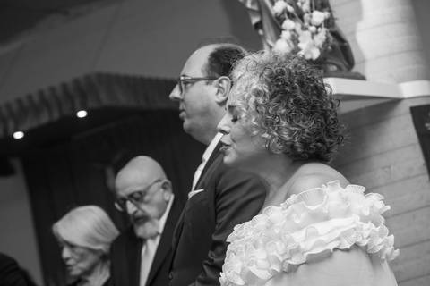 Fotografia de sentimento dos noivos orando de olhos fechados durante a cerimônia de casamento. Registro por Bruno Arita.'