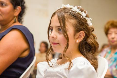 Retrato documental da filha pequena dos noivos em momento de atenção e leveza na igreja. Foto por Bruno Arita.'