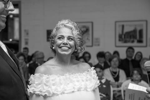 Noiva Tabatha com olhar de amor e sorrindo para o noivo Danilo durante a cerimônia. Foto em preto e branco por Bruno Arita.'