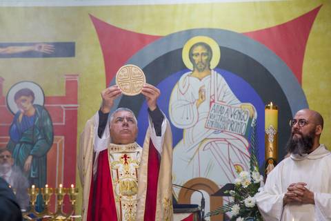 Close do padre segurando o pão que será consagrado na cerimônia de primeira Eucaristia da noiva. Registro por Bruno Arita.'