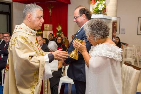 Noiva Tabatha bebendo o vinho no cálice dourado durante o rito da primeira Eucaristia. Registro por Bruno Arita.'