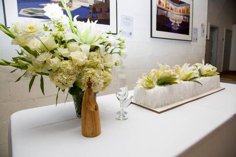 Fotografia de detalhes da mesa de doces e do bolo de casamento decorado com flores frescas. Foto por Bruno Arita.'