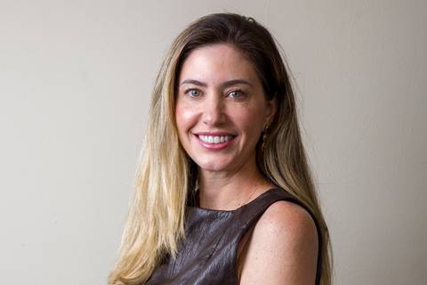 Retrato horizontal de perfil de médica sorrindo, usando vestido de couro marrom escuro acinturado, clicada por Bruno Arita. Fotografia de posicionamento de imagem e marketing médico para a SCOPO MetLife no Rebouças.'