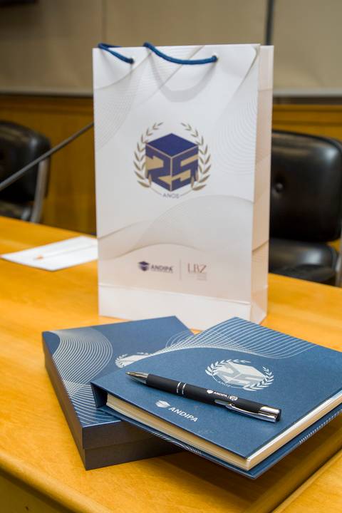 Sacola de presentes, caderno institucional e quadro decorativo dos 25 anos da ANDIPA na FIESP. Registro de detalhes corporativos por Bruno Arita.'