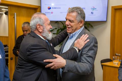 Abraço entusiasmado entre empresários do setor de papel durante o evento de 25 anos da ANDIPA na FIESP. Foto de conexões por Bruno Arita.'