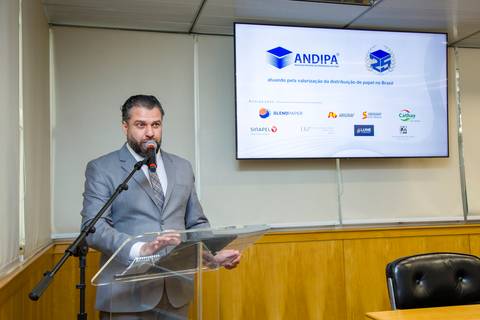 Apresentador conduzindo a abertura institucional dos 25 anos da ANDIPA no auditório da FIESP. Fotografia corporativa por Bruno Arita.'