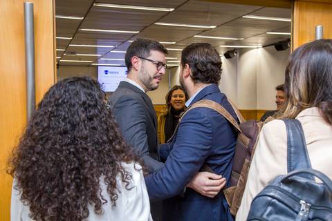 Participantes se cumprimentando e conversando na entrada do auditório da FIESP. Foto de recepção e evento corporativo por Bruno Arita.'