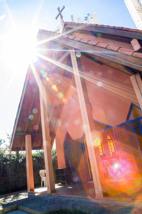 Raios de luz solar atravessando o vitral colorido no teto da Capela Santa Suzana. Fotografia conceitual por Bruno Arita.'