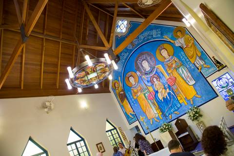 Vista interna do teto de madeira e painel sacro iluminado na Capela Santa Suzana no Morumbi. Foto por Bruno Arita.'