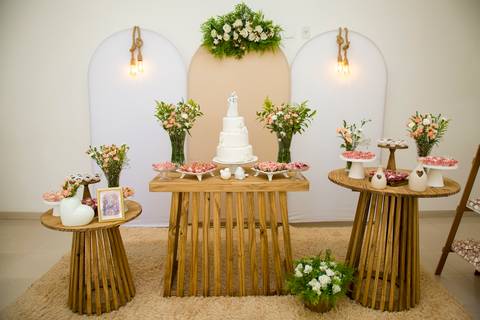 Mesa de doces decorada com bolo de casamento e arranjos florais para o receptivo. Foto por Bruno Arita.'