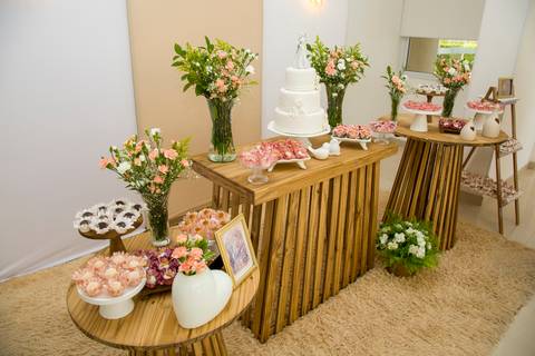 Decoração rústica e elegante da mesa de doces com bolo branco e flores delicadas. Foto por Bruno Arita.'