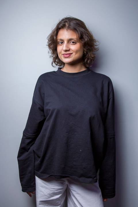 Retrato profissional de mulher com blusa preta posando para foto de perfil corporativo. Foto por Bruno Arita.'