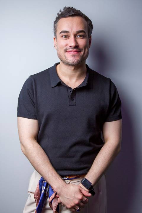 Retrato corporativo masculino de homem em camiseta preta posando para atualização de LinkedIn. Foto por Bruno Arita.'