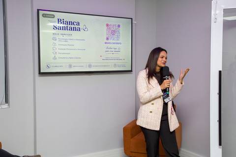 Palestrante convidada discursando em frente à tela com apresentação da marca Bianca Santana. Foto por Bruno Arita.'