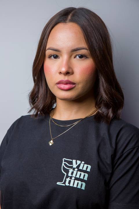 Retrato corporativo de jovem mulher vestindo camiseta preta da marca Vintimtim. Foto por Bruno Arita.'