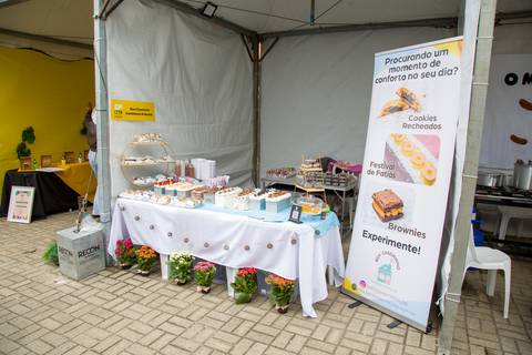 Visão geral da barraca de doces e brownies com banner promocional da Bem Caseirinho SP de Renata Mendes no Festival SPcria. Foto por Bruno Arita.'
