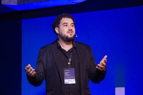 Palestrante Jean Rios no Palco: Palestrante discursando no palco principal do AI Growth Summit IdealTrack em São Paulo. Foto por Bruno Arita.'