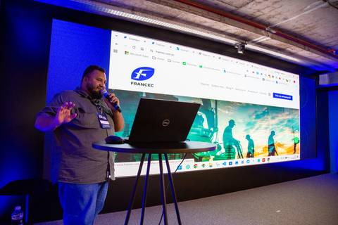 Apresentação de Case: Palestrante compartilhando resultados e cases digitais em tela grande no evento corporativo em SP. Foto por Bruno Arita.'