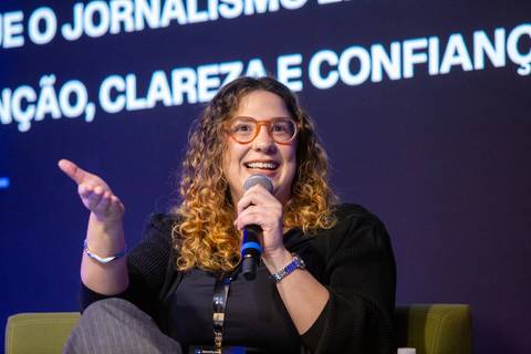 Palestrante de Óculos em Painel: Jornalista e palestrante discursando sobre transparência e autoridade na era digital em SP. Foto por Bruno Arita.'