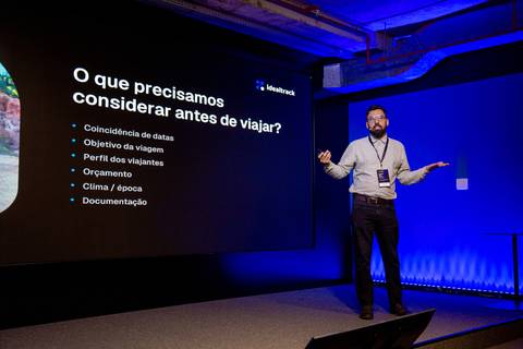 Palestrante da CVC e Slide de Viagem: Palestrante apresentando fatores de decisão de viagem na era da inteligência artificial em SP. Foto por Bruno Arita.'