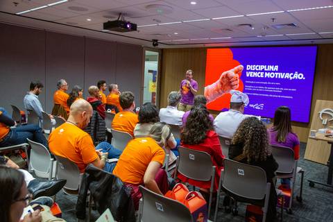 Palestra sobre Disciplina e Motivação: Convidado apresentando dados e métricas na tela principal do auditório em SP. Foto por Bruno Arita.'