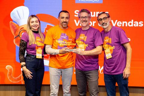 Premiação no Summit BRCondos com quatro participantes segurando um troféu de premiação no palco do evento. Foto: Bruno Arita.'