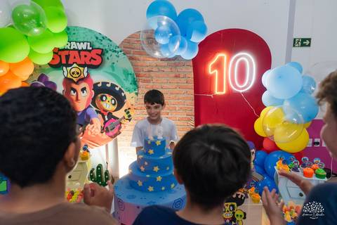 Aniversariante observando o bolo com atenção'