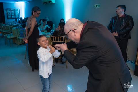 Pai da debutante brincando com convidado mirim'