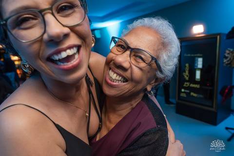 Mãe e avó da debutante com sorriso marcante'