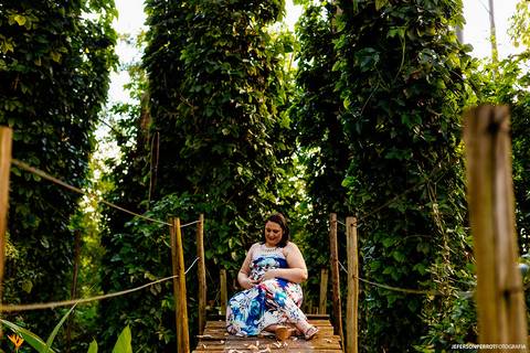 gestante sentada em ponte em ensaio fotografico'