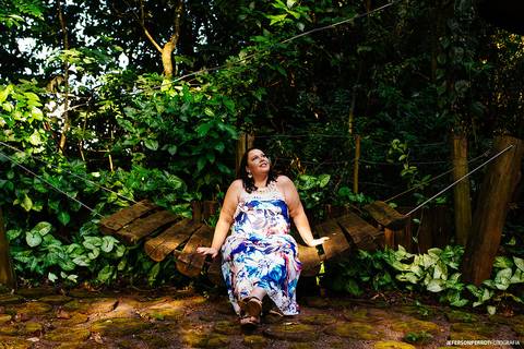 gravida sentada em espreguicadeira de madeira em ensaio fotografico'