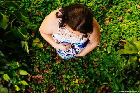 gestante de vestido azul florido em ensaio fotografico'