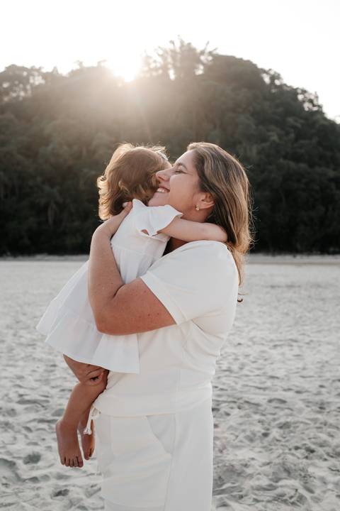 foto de mãe e filha se abraçando na praia'