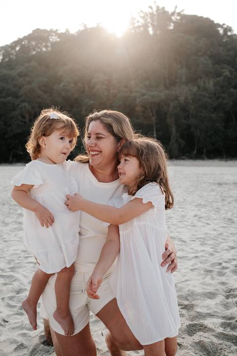 retrato de mãe com filhas na praia'