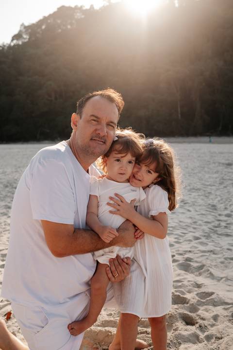 foto na praia de pai e filhas'