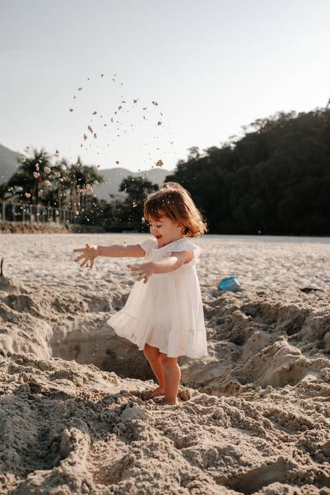 sessão de foto na praia infantil brincando na areia'