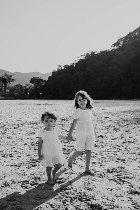sessão de fotos em família na praia com irmãs em preto e branco'