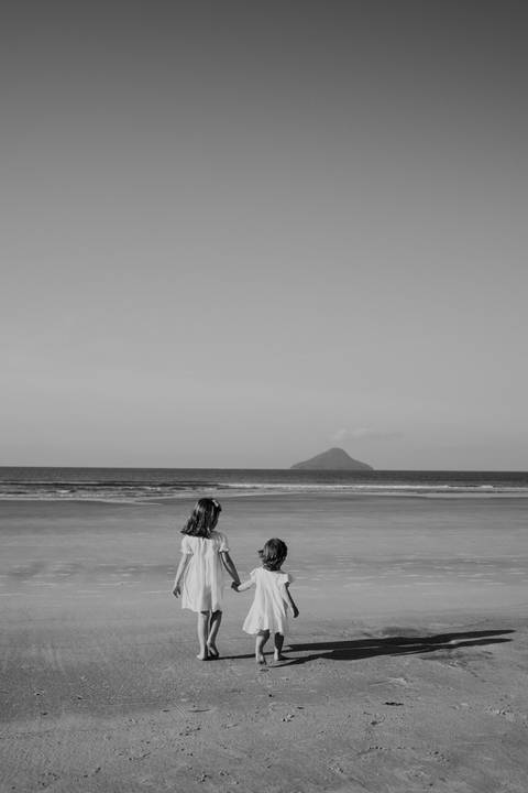 ensaio familiar com foto de irmãs na praia em preto e branco'
