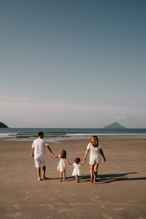 ensaio fotográfico em família caminhando para o mar'