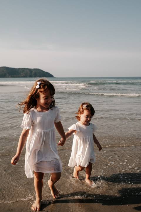 fotografia de irmãs na praia ao por do sol'