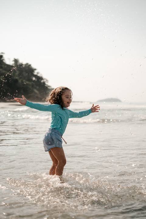 criança brincando na água em ensaio fotográfico'
