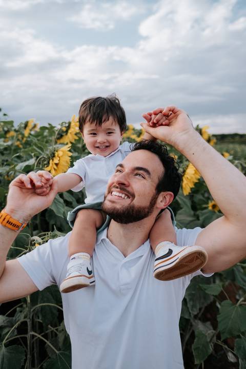 retrato pai e filho em campo de girassóis '