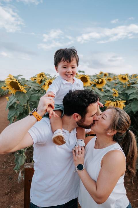 retrato familiar de acompanhamento 1 ano em campo de girassóis'