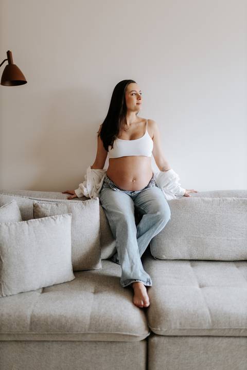 ensaio gestante em casa com foto criativa no sofá'