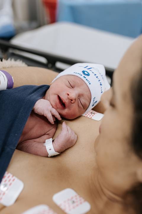 Foto do recém-nascido deitado no peito da mãe logo após o nascimento'