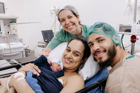 Foto da família sorrindo após o nascimento na Maternidade Santa Maria'